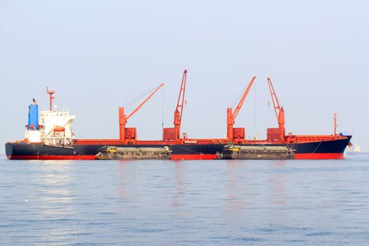 Cargo ship sailing in still water near port.