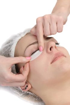 wiping mascara from eyelashes before facial mask procedure