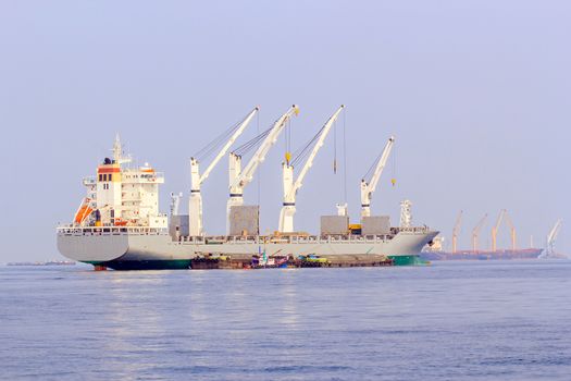 Cargo ship sailing in still water near port.