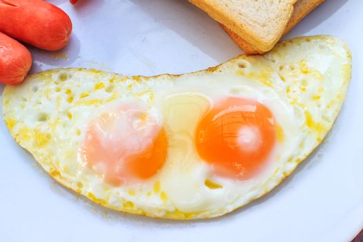 Breakfast with fried eggs, Sausage, toasts. Closeup.