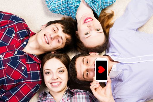 four young people are together, the young man pressed his lips to the phone