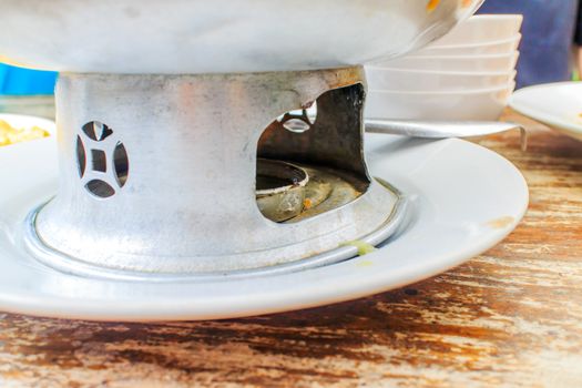 The old pot placed on a wooden table for restaurant