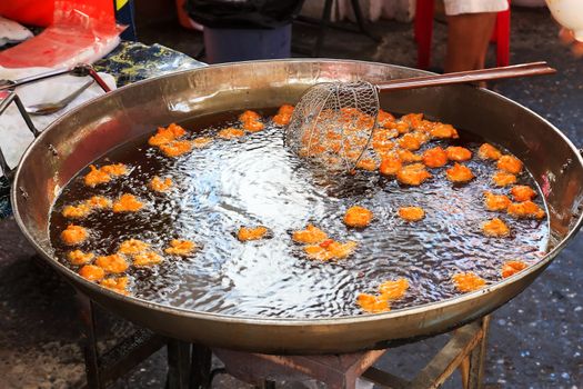 Fried fish patty is fried in boiling oil.