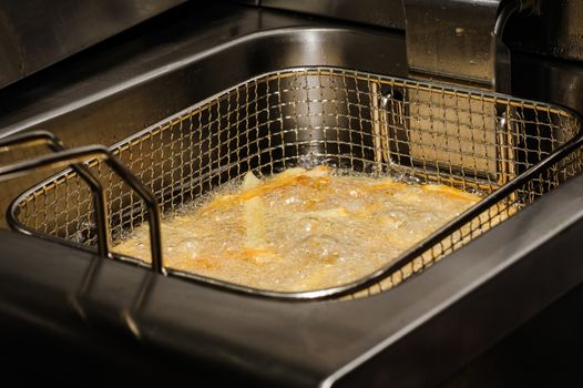 french fries being cooked in electric fryer