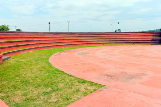 Red grandstand in arena with blue sky