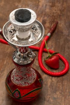 An ornate Syrian sheesha or hooka water pipe on wood table