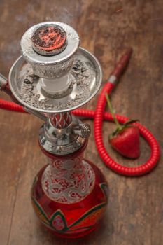 An ornate Syrian sheesha or hooka water pipe on wood table