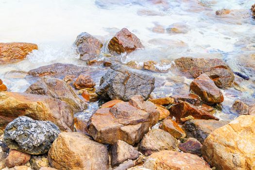 Rocky beach and surf with the sea.