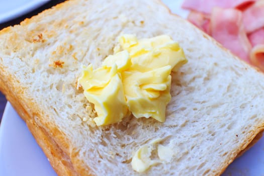 The toast topped with butter in white dish.