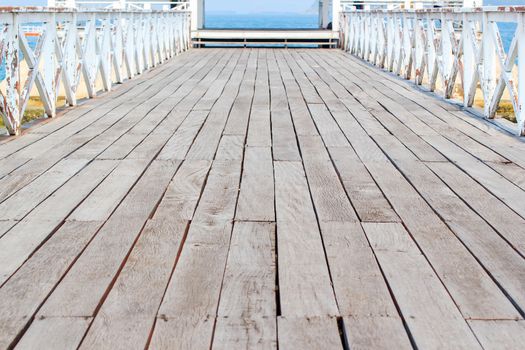 Walking on a wooden bridge in the middle of the sea.