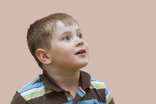 Happy baby boy in surprise on a pink background