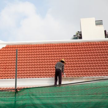 painter paintting new paint at soffit on roof