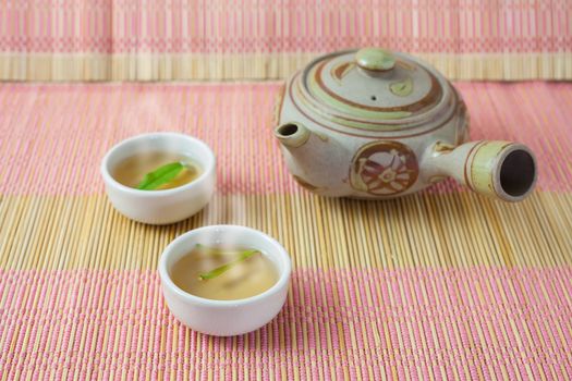 teapot,tea cup and tea leaves on a bamboo table