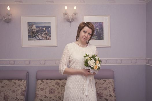 bride with a bouquet of flowers in interior
