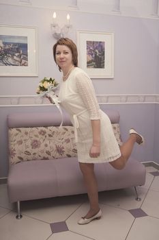 bride with a bouquet of flowers in interior