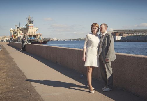 couple walk along the embankment of the river