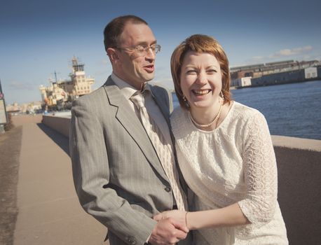 couple walk along the embankment of the river