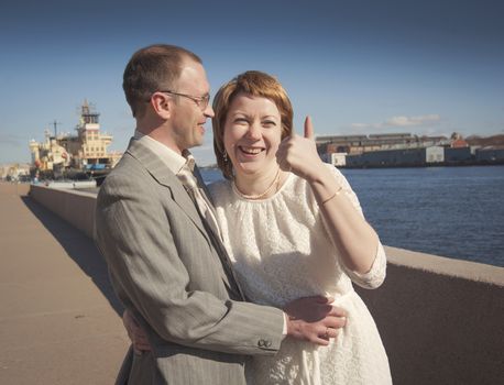 couple walk along the embankment of the river