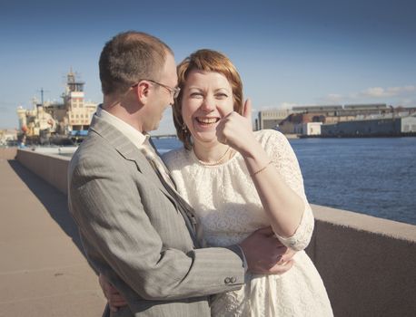 couple walk along the embankment of the river