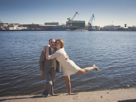 couple walk along the embankment of the river