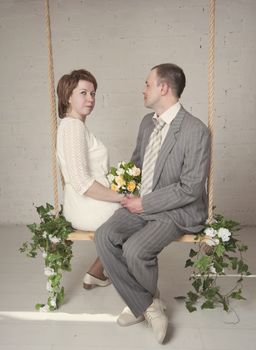 bride and groom are swinging in the Studio