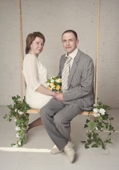 bride and groom are swinging in the Studio