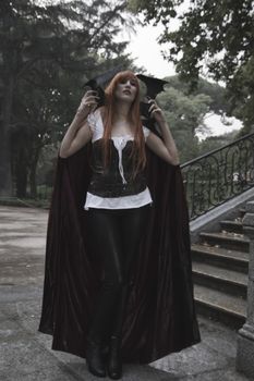 Dark beauty under rain, red hair woman with long black coat