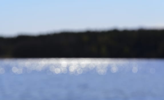 Sunshine on a lake and island blurry background, Lake Malaren, Stockholm, Sweden in May.