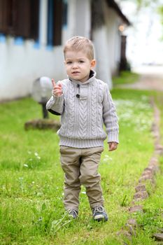 Trendy 2 years old baby boy posing in spring/autumn park