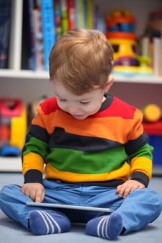 Happy 2 years old boy using a digital tablet computer