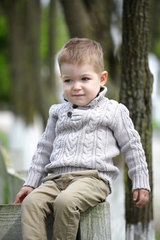 Trendy 2 years old baby boy posing in spring/autumn park