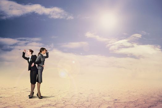 two business women holding hands, looking in different directions, teamwork