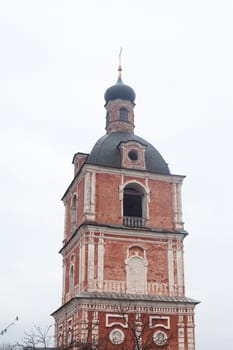Red orthodox church with grey dome
