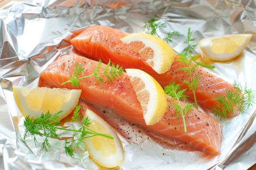 Fresh salmon fillets with lemon wedges and dill