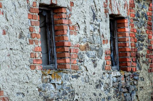 Two windows in the old stone brick wall.