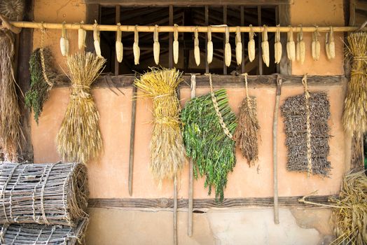 Wall of an  old house with drying corn and vegetables