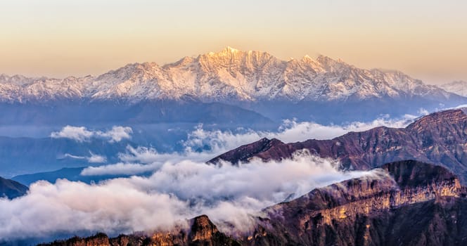 Minya Konka snow mountain with the clouds sea under the sunrise in Niubei mountain of Sichuan province of China.