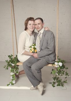 bride and groom are swinging in the Studio