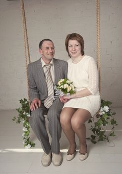 bride and groom are swinging in the Studio