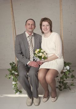 bride and groom are swinging in the Studio