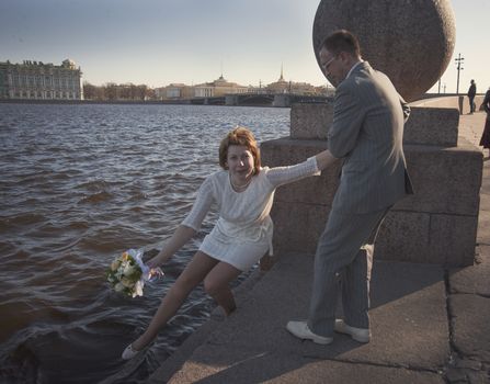 couple walk along the embankment of the river