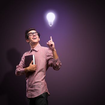 young man holding a book in front of him, raised his hand, the idea