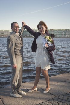 couple walk along the embankment of the river