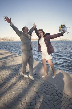 couple walk along the embankment of the river