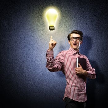 young man holding a book in front of him, raised his hand, the idea