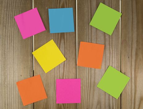 wooden wall with papers in green yellow blue pink and orange