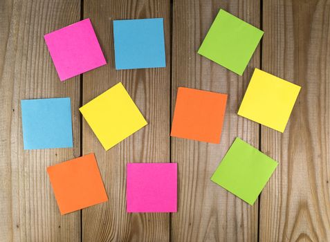 wooden wall with papers in green yellow blue pink and orange