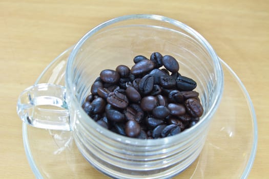 coffee beans in cup on the wood table