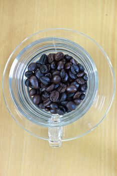 coffee beans in cup on the wood table