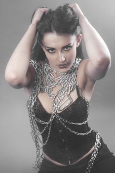 Beautiful brunette woman with big silver chains chained
